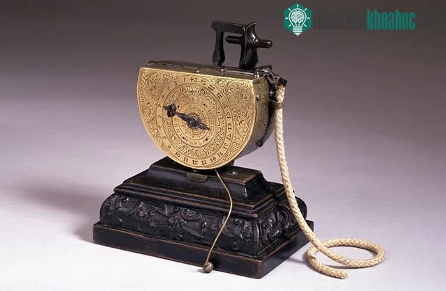 Đồng hồ báo thức để bàn được làm bằng thép, đồng thau và gỗ óc chó.
