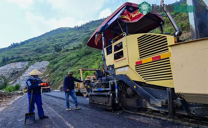 Hàng chục công nhân đang hoàn thành khoảng 100m đường dẫn lên cầu Móng Sến.