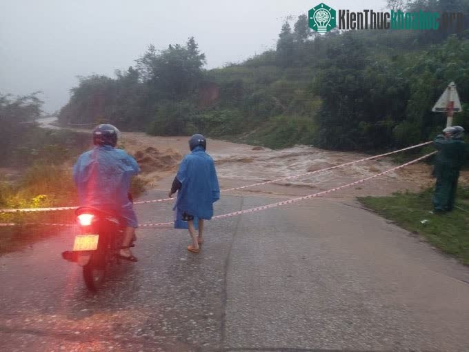 Lực lượng chức năng phong toả một đoạn đường do nước lũ chia cắt, sáng 28/9.