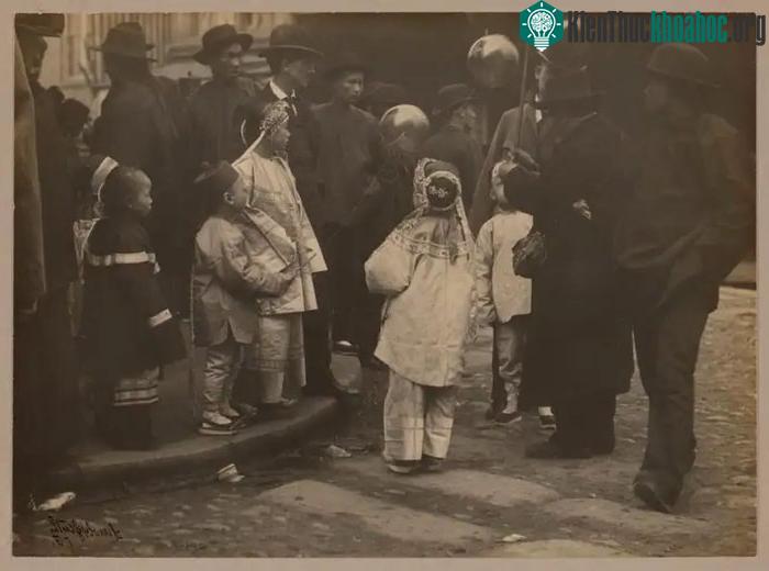 Trẻ em quây quanh một người đàn ông bán bóng bay, 1900