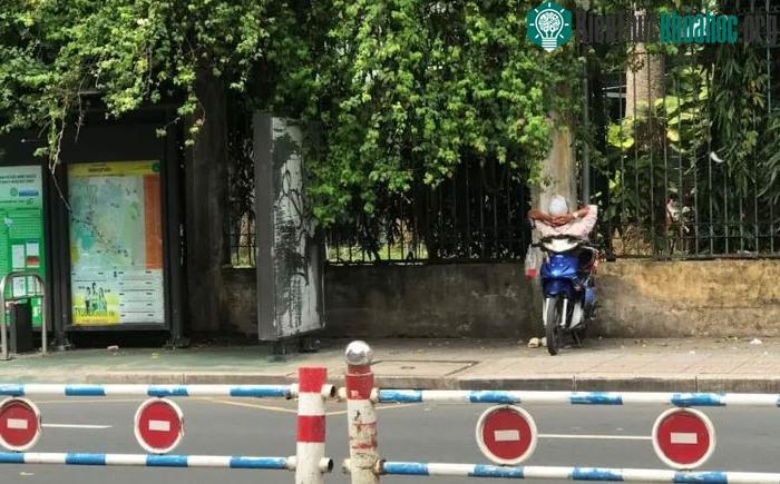 Người lái xe ôm ngủ trên chiếc xe máy ở Việt Nam.