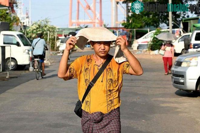 Một người đàn ông trùm khăn lên đầu để tránh nắng trong đợt nắng nóng ở Yangon