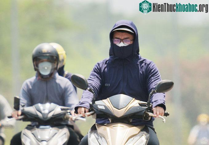 Người dân tham gia giao thông giữa trời nắng nóng trên Đại Lộ Thăng Long, Hà Nội.