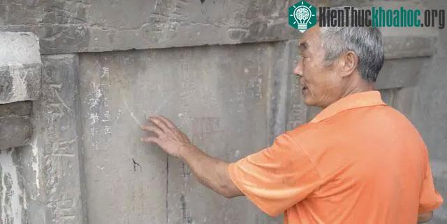 Bia đá gần cầu có ghi rõ về năm xây dựng và tên của những người quyên góp chi phí xây cầu.