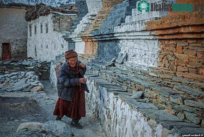 Một già làng đang đi bộ theo chiều kim đồng hồ quanh bảo tháp,