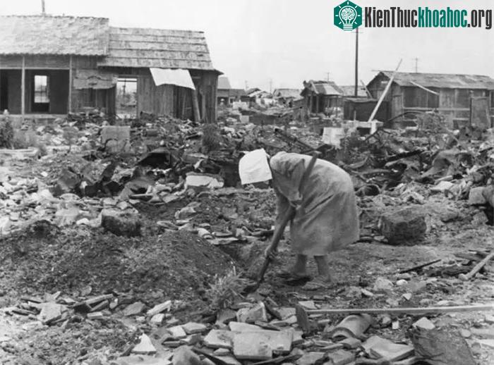 Người phụ nữ dọn dẹp giữa đống đổ nát hoang tàn