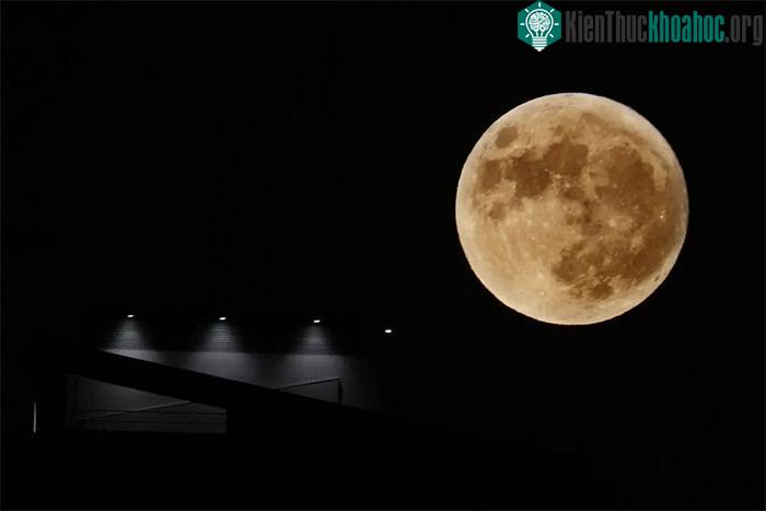 Trăng tròn mọc bên cạnh đèn chiếu của một tòa nhà ở Beirut, Lebanon