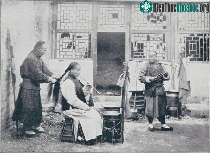 Thợ cắt tóc mang đồ nghề đi quanh phố làm việc.