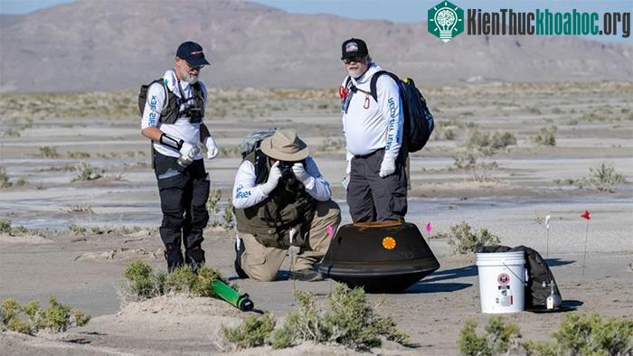 Nhân viên NASA tiếp cận để thu hồi khoang chứa mẫu vật chất.