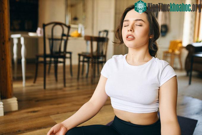 Một người phụ nữ tập thở tại nhà vào buổi sáng.