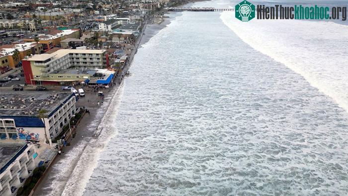 Sóng tràn lên lối đi bộ lát ván tại Bãi biển Mission ở San Diego