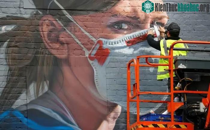 Một nghệ sĩ đang vẽ tranh tường trong đại dịch Covid-19 ở Manchester.