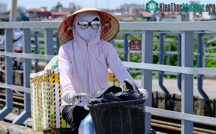 Một người dân Hà Nội trùm kín khi ra đường giữa trưa nắng