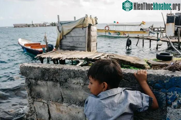 Một bé trai chơi ở bức tường gần bờ biển trên đảo Gardi Sugdub.