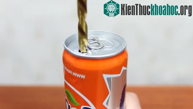 Trước tiên bạn hãy khoan 1 lỗ to ở phần đầu của lon nước ngọt.