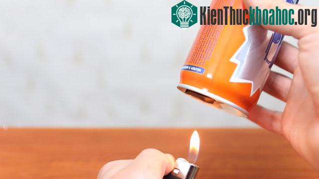 Sau đó bạn hãy dùng bật lửa để hơ nóng miếng cao su sao cho nó dính chặt vào nắp lon nước.