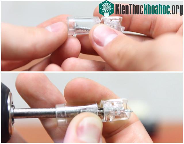 Cho một con ốc vào và xoay nó sao cho đầu nhọn óc xuyên lên phía trên của nắp bút bi.