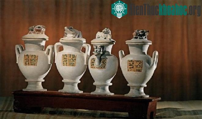 Bình đá vôi với phần nắp độc đáo được đặt trên bệ đỡ sơn đỏ.