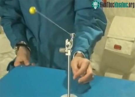 Vương Á Bình dùng một quả bóng và sợi dây để minh họa chuyển động của con lắc trong vũ trụ. (Ảnh: CCTV)
