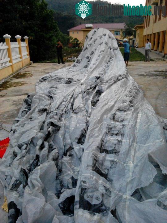 Vật thể này màu xám, trên thân có in nhiều hình ảnh mặt người.