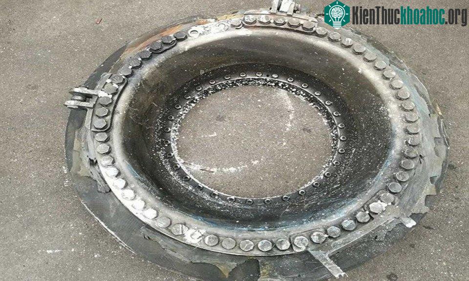 Mảnh vỡ hình đĩa bằng kim loại với nhiều đinh tán được người dân tìm thấy tại hiện trường.