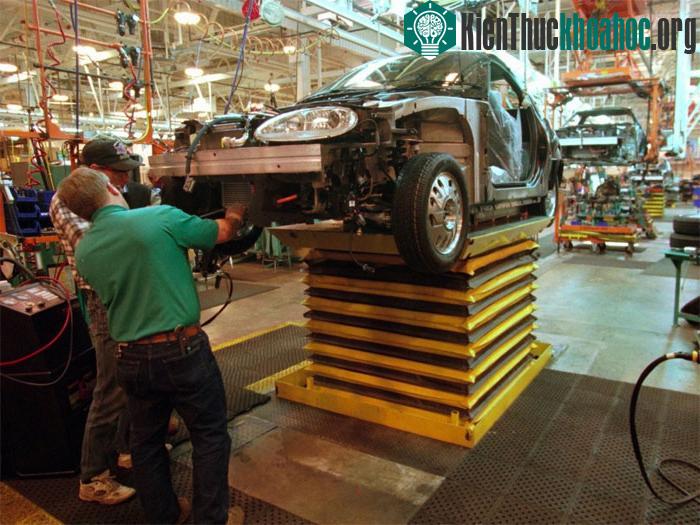 Công nhân tại một nhà máy General Motors lắp động cơ vào điện vào chiếc xe mới trong năm 1996.