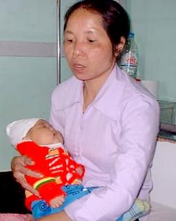Bé Bùi Thị Thu, 3 tháng tuổi đang trong vòng tay của mẹ