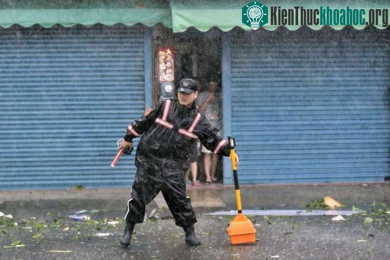 Cảnh sát giao thông dựng tín hiệu cảnh báo trước lối vào một con đường cấm qua lại do ảnh hưởng của bão Meranti.