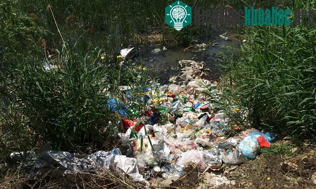 Quang cảnh ô nhiễm nặng nề trên dòng sông Hạnh Phúc. Rác thải ngập ngụa trong dòng nước tối màu. (Ảnh: Guardian).