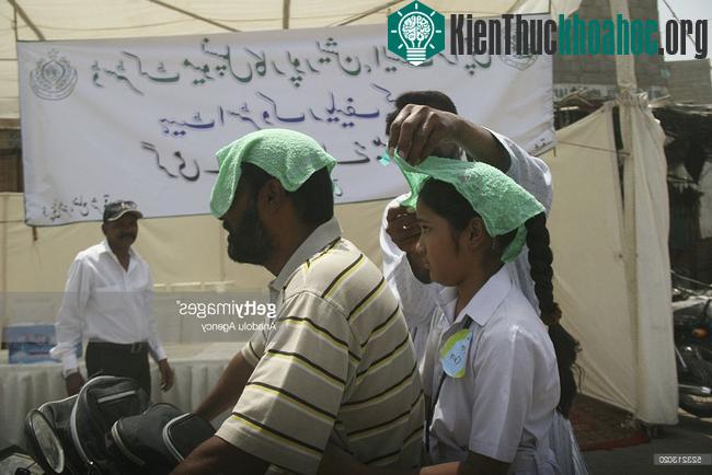 Người tham gia giao thông ở Karachi, Pakistan đội khăn ướt chống nắng.
