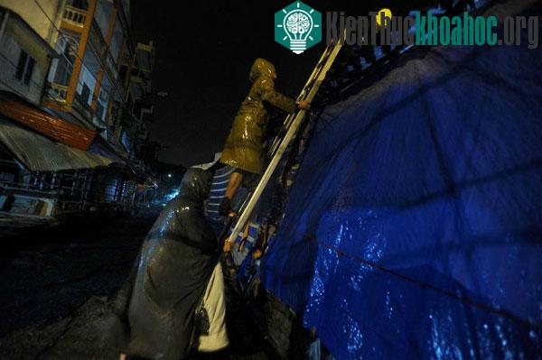 Rất khó khăn mới có thể leo lên để gia cố mái nhà vì gió giật rất mạnh, ảnh chụp lúc 21h45 tại đường Kỳ Lừa, Đồng Đăng, Lạng Sơn. (Ảnh: Giang Huy)