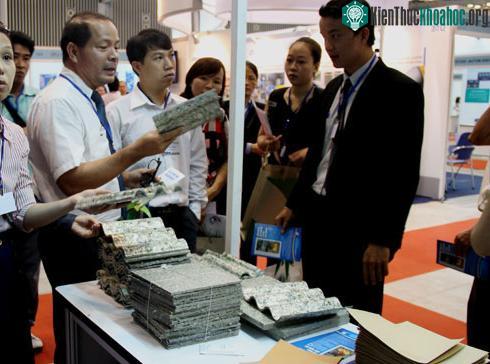 Nhiều khách tham quan triển lãm tìm hiểu công dụng tấm lợp sinh học từ rác thải. (Ảnh: Thi Ngoan)