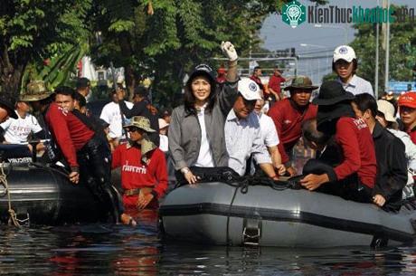 Thủ tướng Thái Lan Yingluck Shinawatra cho người dân xem bóng vi sinh trong lúc thị sát tại Bangkok hôm 3/11. (Ảnh: AFP)