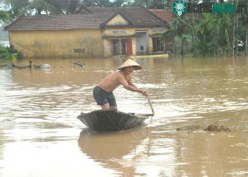 Mưa lũ chia cắt, người dân miền Trung phải đi lại bằng ghe trên biển nước mênh mông. (Ảnh: Trí Tín)