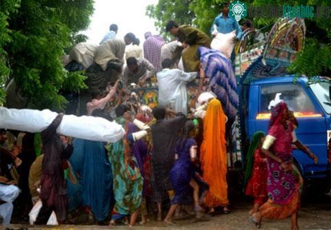 Người dân quận Umerkot, tỉnh Sindh, Pakistan chen chúc lấy hàng cứu trợ của chính phủ trên một chiếc xe tải. (Ảnh: AFP)