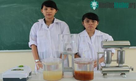 Thảo Quỳnh (bìa phải) và Hoàng Yến cạnh mô hình "Hệ thống xử lý nước mưa khép kín". (Ảnh: Xuân Lương).