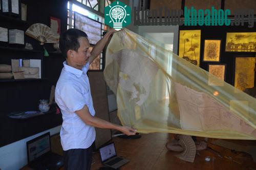 Anh Thọ và sản phẩm giấy dán trên dải lụa - (Ảnh: Tam Liên).