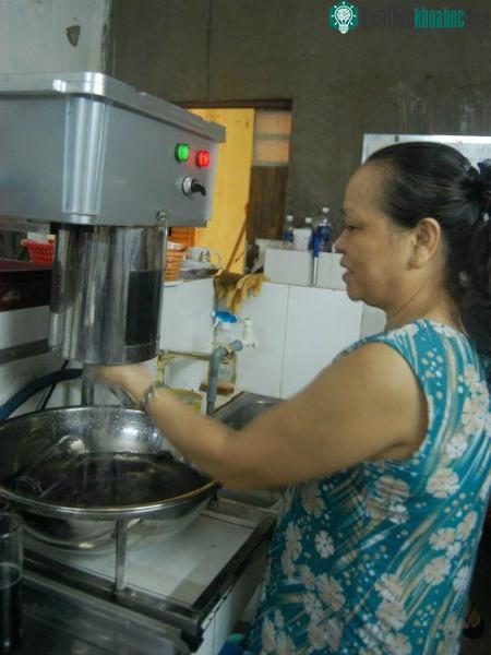 Nhân viên sử dụng máy rửa ly tại quán cà phê ở quận 10. (Ảnh: Khánh Ly)