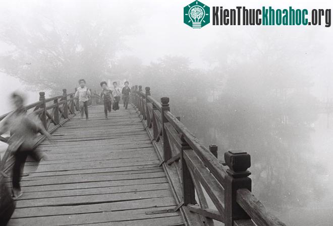 Những đứa trẻ nô đùa trên cầu Thê Húc dẫn vào đền Ngọc Sơn.