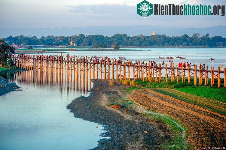 Các nhà sưu đi qua cây cầu U Bein, bắc ngang qua hồ Taungthaman gần Amarapura, Myanmar. Cây đầu xây năm 1850 được cho là cây cầu gỗ tếch lâu đời và dài nhất thế giới.