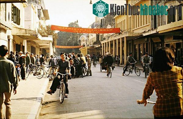 Một góc phố Hà Nội vào năm 1979. Phía xa là Hồ Gươm. Nơi tấm băng - rôn đầu tiên là ngã ba Tràng Tiền - Nguyễn Xí. Phía ngay cạnh phải của hình là rạp Công Nhân và nhà sách Tràng Tiền (nay là Trung...