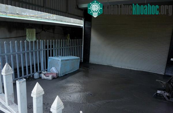 Chiếc tủ lạnh trôi nổi trong lũ giờ yên vị trên mặt bùn se khô.
