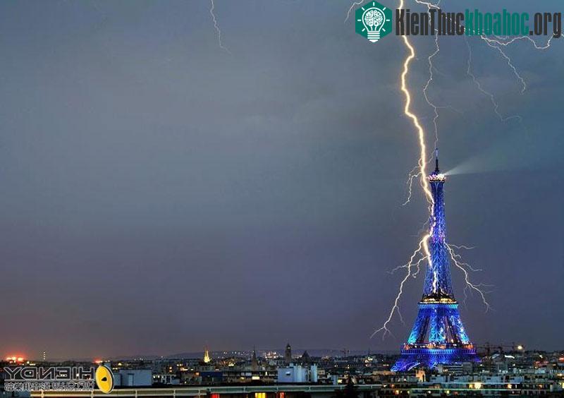 Sét đánh trúng tháp Eiffel được chiếu sáng đèn màu trong đêm ở thành phố Paris, Pháp.