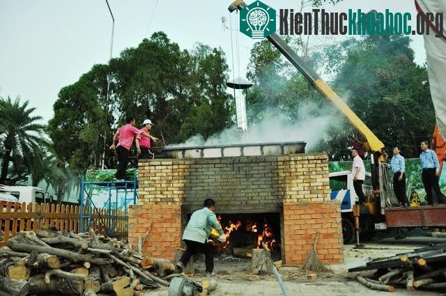 Bánh chứng "khủng" được cẩu đặt trên một bếp và nồi nấu bánh "khủng".