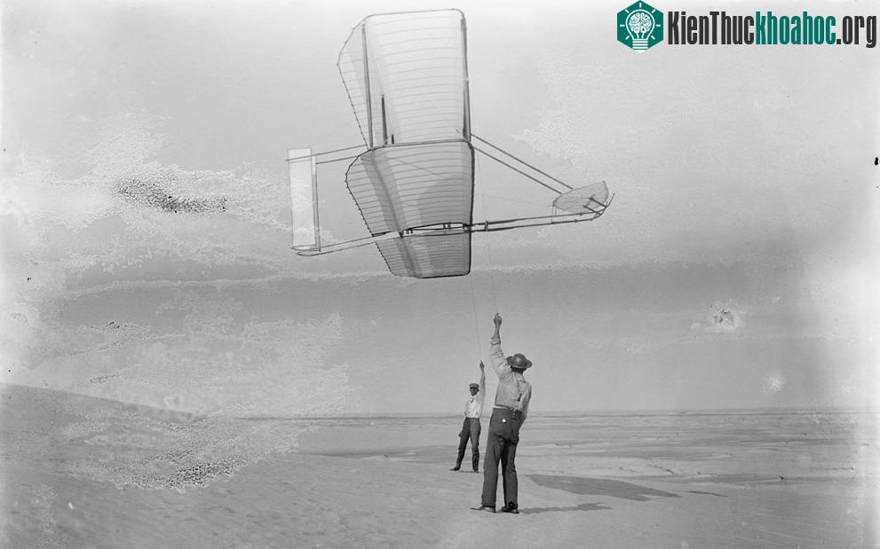 Bên trái là Dan Tate, và bên phải là Wilbur Wright, thả chiếu tàu lượn 1902, vào ngày 19/09/1902.