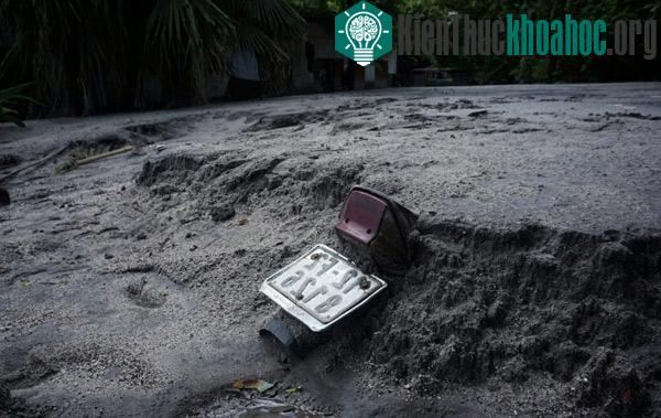 Đuôi một chiếc xe máy lòi trên đống bùn đất.