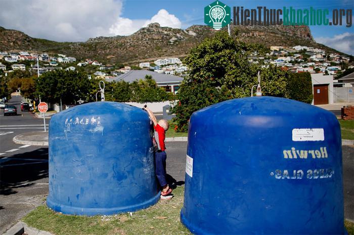 Một cậu bé Nam Phi đổ rác thuỷ tinh vào trong một thùng rác công cộng ở Cape Town, vào Ngày Trái đất, 22/04/2014.