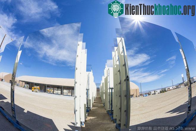 Các tấm gương thu năng lượng phản chiếu hình ảnh của nhà máy và bầu trời.