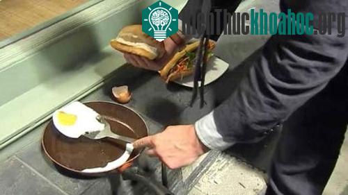 Một phóng viên thử nghiệm nhiệt độ bằng cách rán trứng ốp la dưới chân tòa nhà.