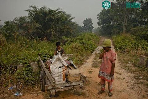 Một phụ nữ và con trai dọn đồ đạc để sơ tán vì lửa lan tới gần ngôi nhà của họ.